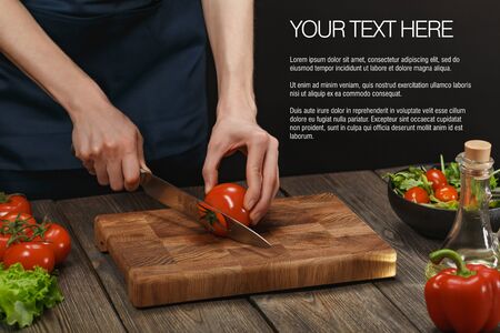 Woman cooking fresh salad. Female hands cutting vegetables on board on wooden table.の写真素材