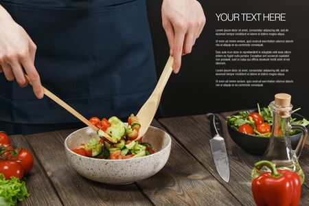 Woman cooking fresh vegetable salad on wooden table. Healthy vegetarian lifestyle.の写真素材