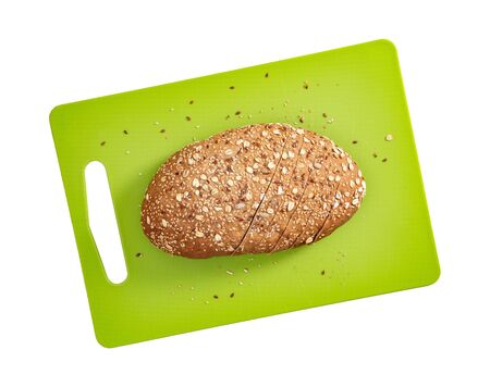 Isolated sliced bread with seeds and flakes on green rectangular cutting board on white background top view.の写真素材