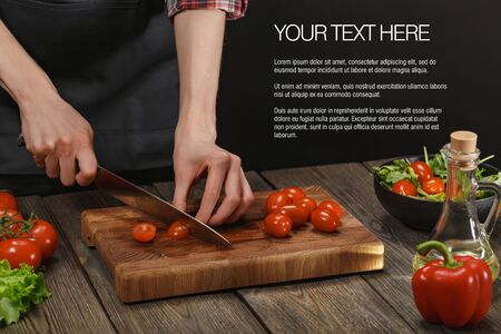 Woman cooking fresh healthy salad. Female hands cutting vegetables on board on wooden table. Diet concept for healthy lifestyle.の写真素材