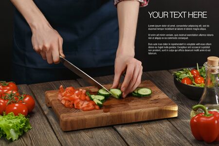 Woman cooking fresh healthy salad. Female hands cutting vegetables on board on wooden table. Diet concept for healthy lifestyle.の写真素材
