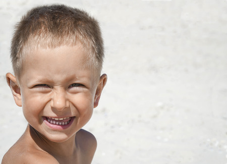 Portrait of little boy smiling on the background of the sea beachの写真素材