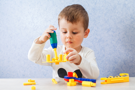 Cute little boy is playing with tools. A toddler working with toy tools. A little craftsmanの写真素材