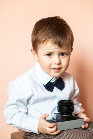 Little boy with aged retro camera. Young photographer. Child with an old cameraの写真素材
