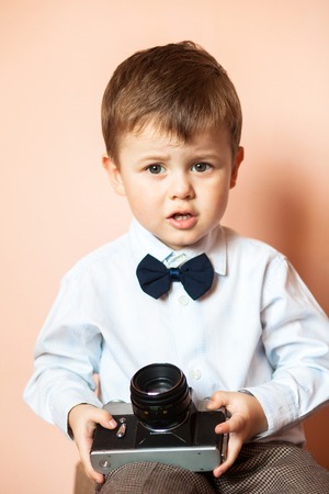 Little boy with aged retro camera. Young photographer. Child with an old cameraの写真素材