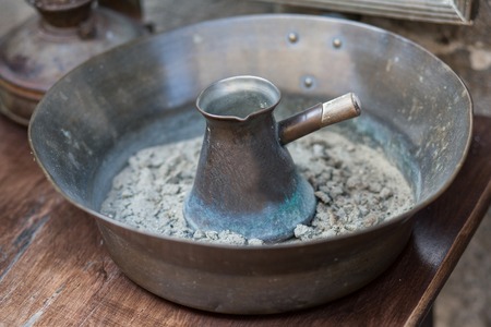 Traditional turkish coffee in cezve prepared on hot sand.