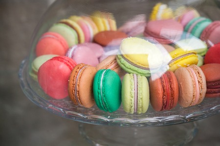 Sweet and colorful French macarons in glass bowl. Macarons cakes in glass bowl