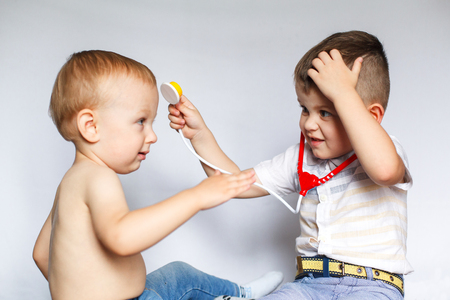 Children playing doctor and patient. Two little boys using stethoscope. Check the heartbeat. Kids play doctorの写真素材