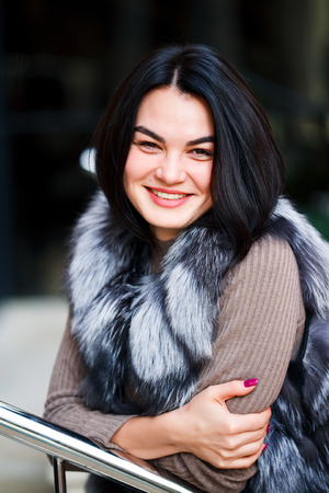 Stylish woman walking In the city in Fur-Vest. Urban street style, fashion trend. Fashion outdoor photo of sexy beautiful womanの写真素材
