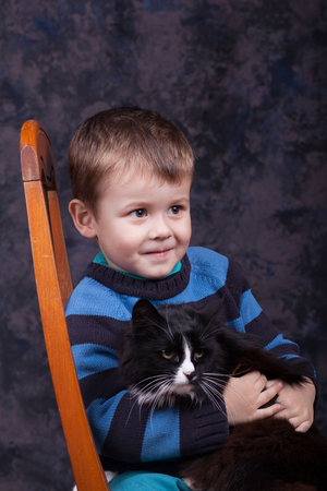 Little boy holding a black cat. Boy and kitten.の写真素材