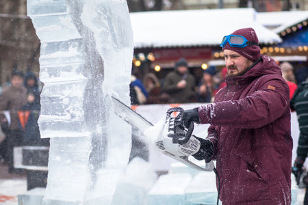 Ukraine, Lviv - January 11, 2019: Master makes ice sculptures from ice. The sculptor cuts ice contours from ice with a chainsawのeditorial素材