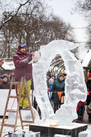 Ukraine, Lviv - January 11, 2019: Master makes ice sculptures from ice. The sculptor cuts ice contours from ice with a chainsawのeditorial素材