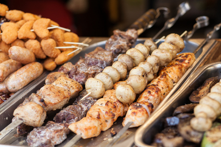 Different types of delicious meat and mushrooms on skewers. Outdoor Cuisine Culinary Buffet.の写真素材