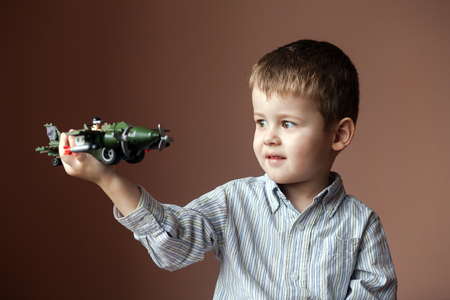 Cute little boy playing with a toy airplane. Military Aircraft LEGOの写真素材