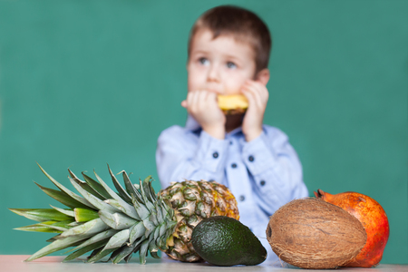 Cute little boy eating pineapple. Concept healthy eating.の写真素材
