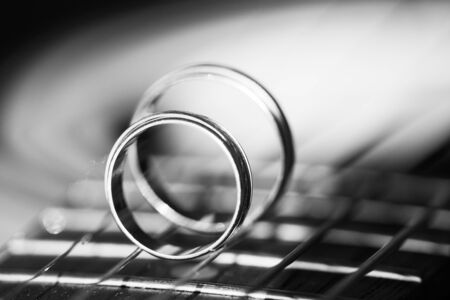 Two Wedding Rings on guitar strings. Two wedding rings standing on guitar fretboardの写真素材