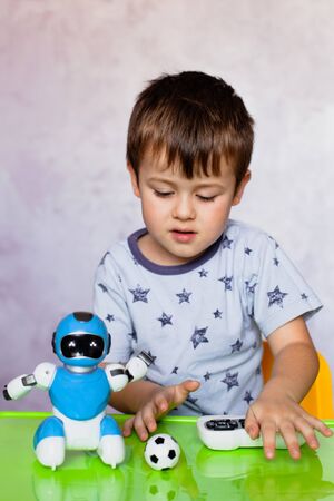 Little boy is playing with robot. Robot for children. Kids and toys. Smart toyの写真素材