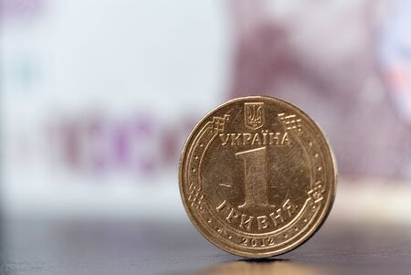 Hryvnia coin on the background of a banknote of 1000 hryvnias. Ukrainian money. Concept earnings. Shallow depth of fieldの写真素材