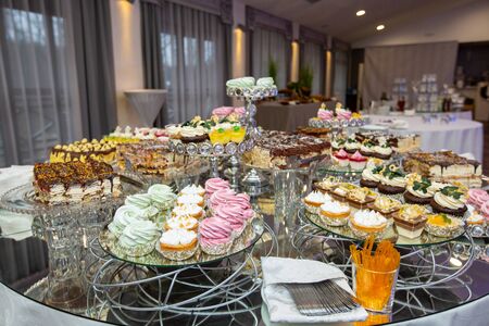 Delicious cream cakes of different kinds close-up. Wedding cupcakesの写真素材