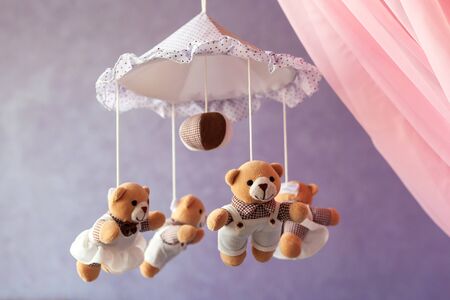 Baby music mobile carousel with little bears. Toy carousel, above the baby bed. Baby bedroom close up element. Device for better baby sleepの写真素材