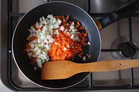 Grated carrot and onion in a frying panの写真素材