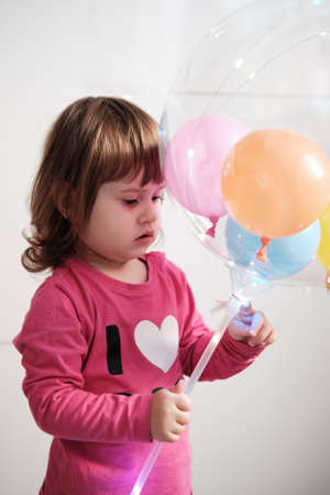 Little girl holding a big Led Light Transparent Ballon With Handle. Life style and childhood.の写真素材