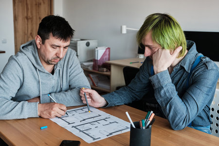 Team of two colleagues interior designers working on architectural project in office. Teamwork, Business Communication.の写真素材