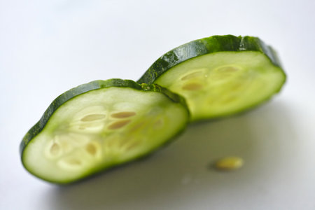 Two slices of fresh cucumber with backlit. Close-up of fresh cucumber with seeds.の写真素材