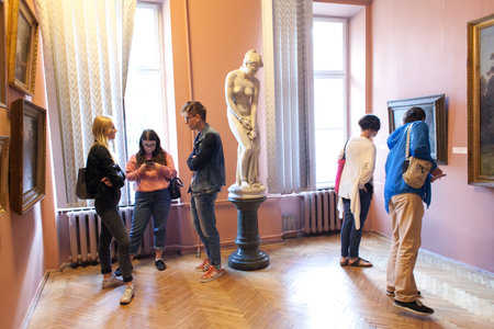 Lviv, Ukraine - September 16, 2018: A group of teenagers on an excursions of Art Gallery. Children in art museum or gallery with guide or teacher. School boys and girls on excursion in museum.のeditorial素材
