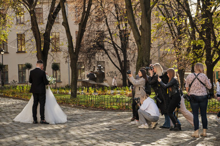 Lviv, Ukraine - October 28, 2022: Wedding Photography Masterclass. Young Attractive Marriage Couple Posing In The Old Town. Photographers shoot the bride and groomのeditorial素材