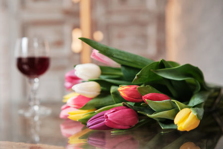 A bouquet of tulips with a glass of wine. Spring flowers, International Women's Day. selective focusの写真素材