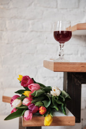 A bouquet of tulips with a glass of wine. Spring flowers, International Women's Day.の写真素材