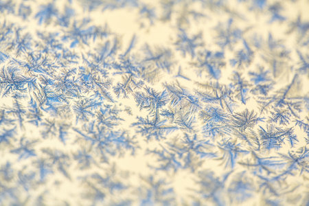 Frost Patterns: Abstract Ice Formations on a Window. Detailed shot highlighting the contrast between...