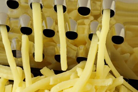 Close up of grated cheese with a graterの写真素材