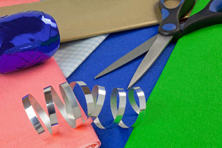Scissors,wrapping paper and ribbon on a tableの写真素材