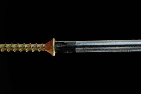 Close-up of a screwdriver driving a brass screw - 36mp image
