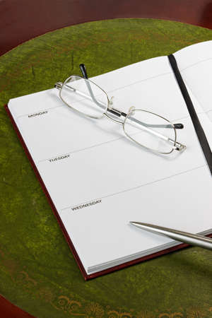 Diary page with pen and glasses. Dates removed.の写真素材