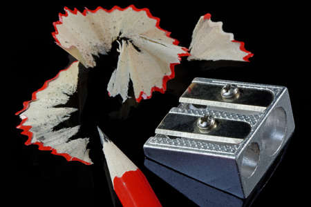 Pencil shavings and sharpener with a pencil on black