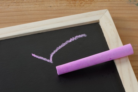 A red tick on a chalkboard with chalk and copy spaceの写真素材