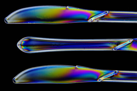 Plastic knives shot in double polarised lighting, in closeupの写真素材