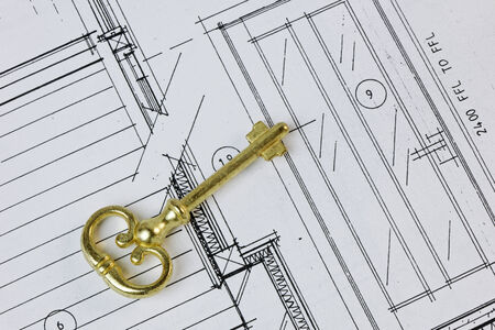 An antique key on a house plan. Ownership/design conceptの写真素材