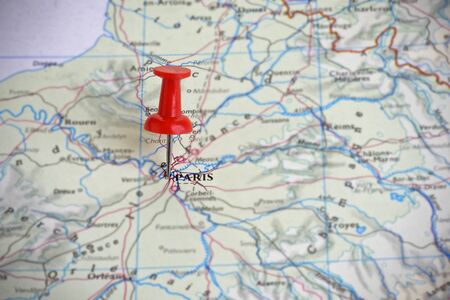 A red push-pin marking Paris on a map of Franceの写真素材
