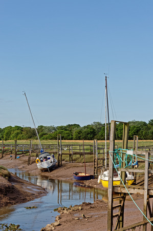 Yachts moored at low tide in Steeping River, Gibraltar Point,UK. A nature reserve on the edge of The Wash in Lincolnshire,UKの写真素材
