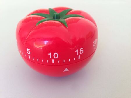 Pomodoro Timer red with green details. Tomato on the table. Vibrant, multi-angle colors. Simply amazing. Inspiration and wisdom with this tool. A wonder this little tomato.の写真素材