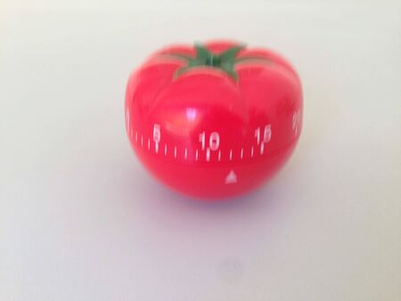 Pomodoro Timer red with green details. Tomato on the table. Vibrant, multi-angle colors. Simply amazing. Inspiration and wisdom with this tool. A wonder this little tomato.の写真素材