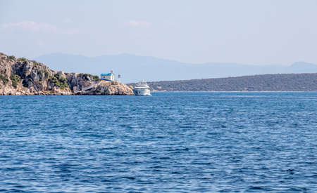 Yate and church at the Kondyli beach Greece. A Flyboard is a brand of hydroflighting device which supplies propulsion to drive the Flyboard into the air to perform a sport known as hydroflyingの写真素材