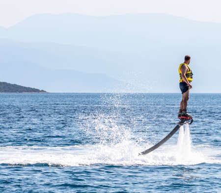 Man doing flyboard in the sea on one of the beaches in Greeceの写真素材