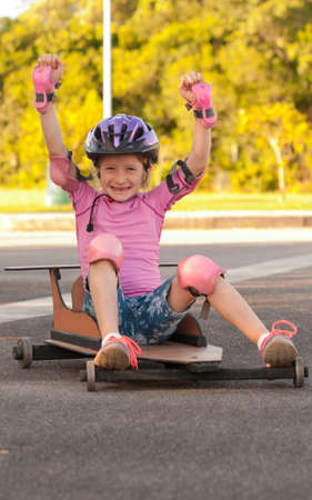 Girl playing with a soapbox cartの写真素材