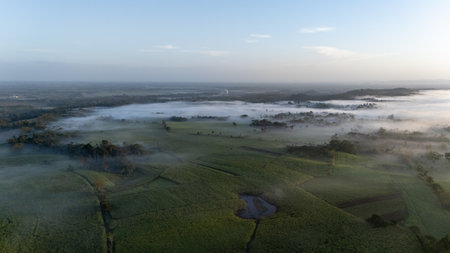 Aerial view of foggy fields and country roads at sunrise in La Fortuna, Costa Rica.の写真素材
