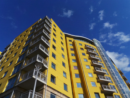 Basingstoke, England - May 22 2013:   A bright yellow block of flats against a blue skyのeditorial素材
